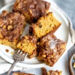 White plate with cake slices on it and silver fork on the side.