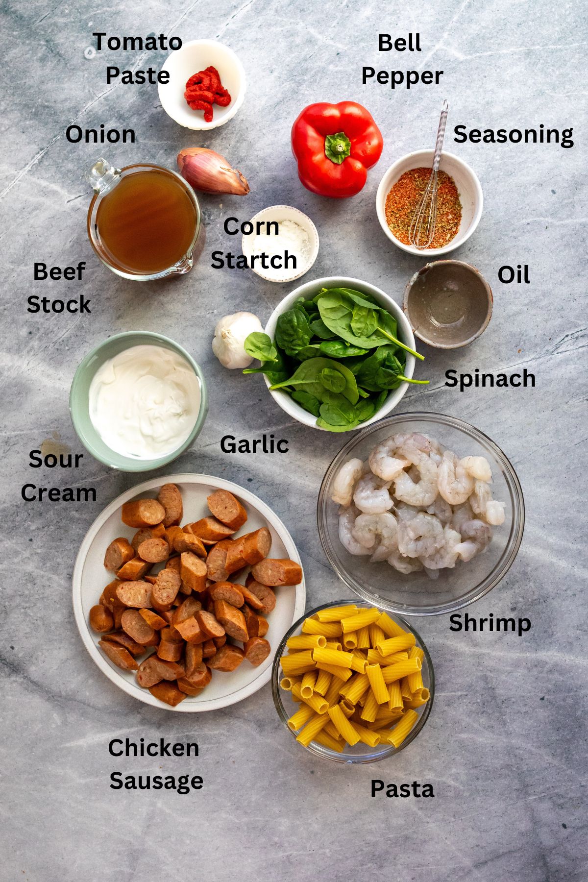 Ingredients needed in small bowls and plates on a counter with herbs and veggies. 