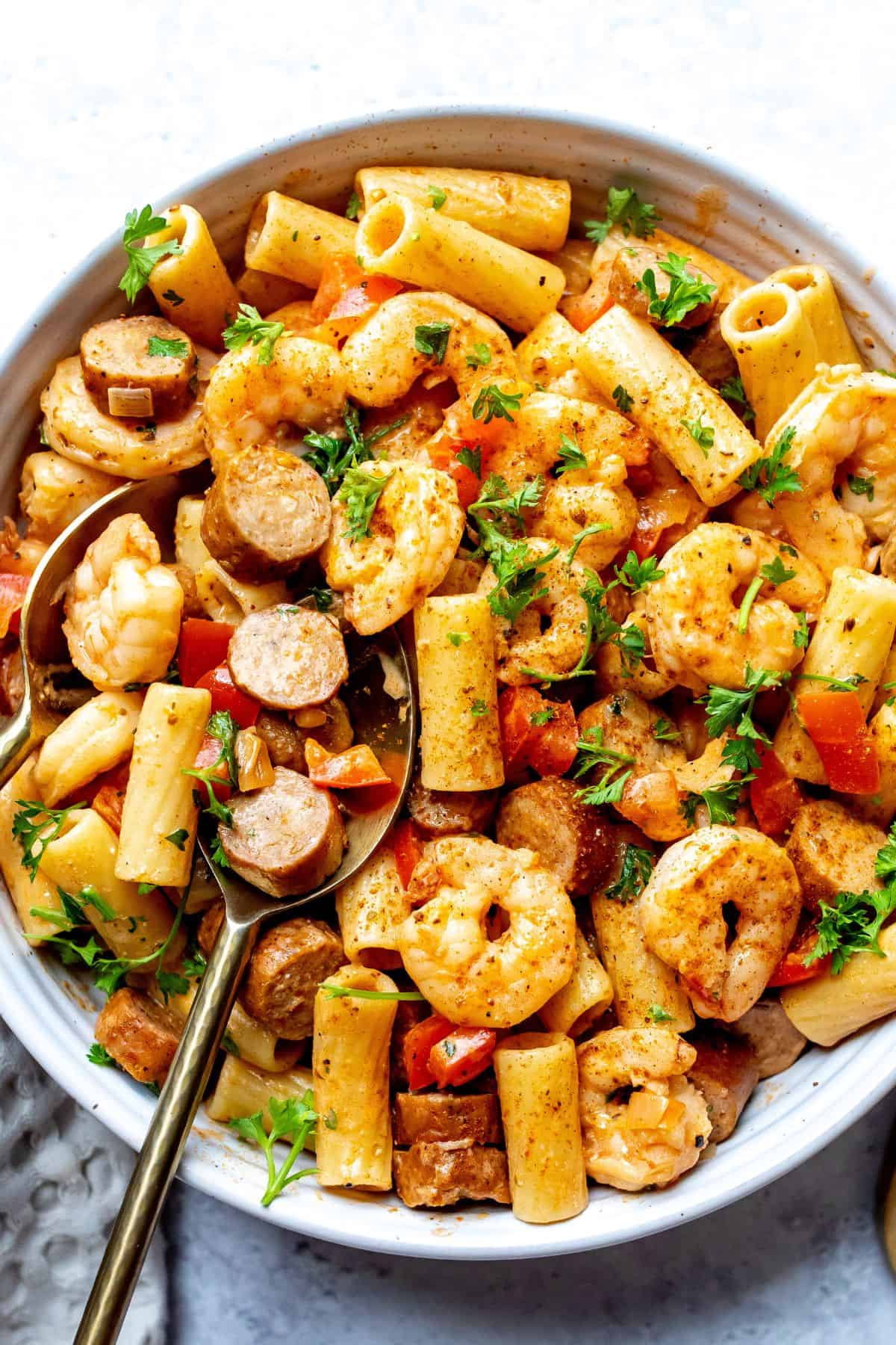 White bowl with texture. Filled with cajun sausage and shrimp pasta.