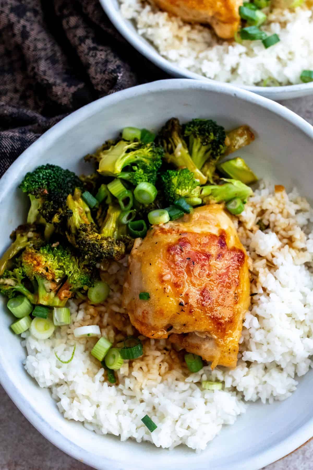 Ceramic bowl with chicken and rice and lots of broccoli inside. 