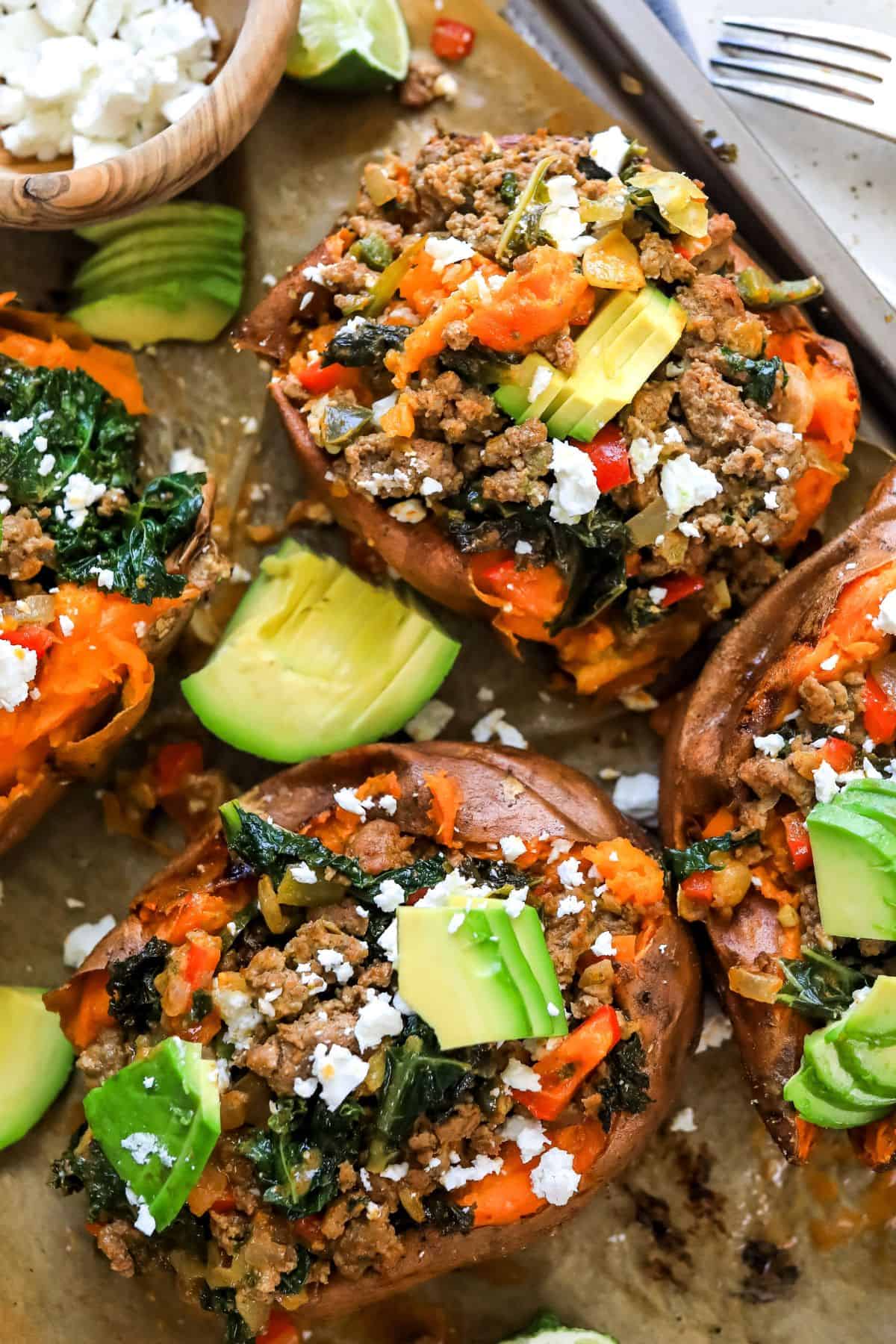 Up close photo of stuffed sweet potatoes with Mexican inspired toppings and avocado.