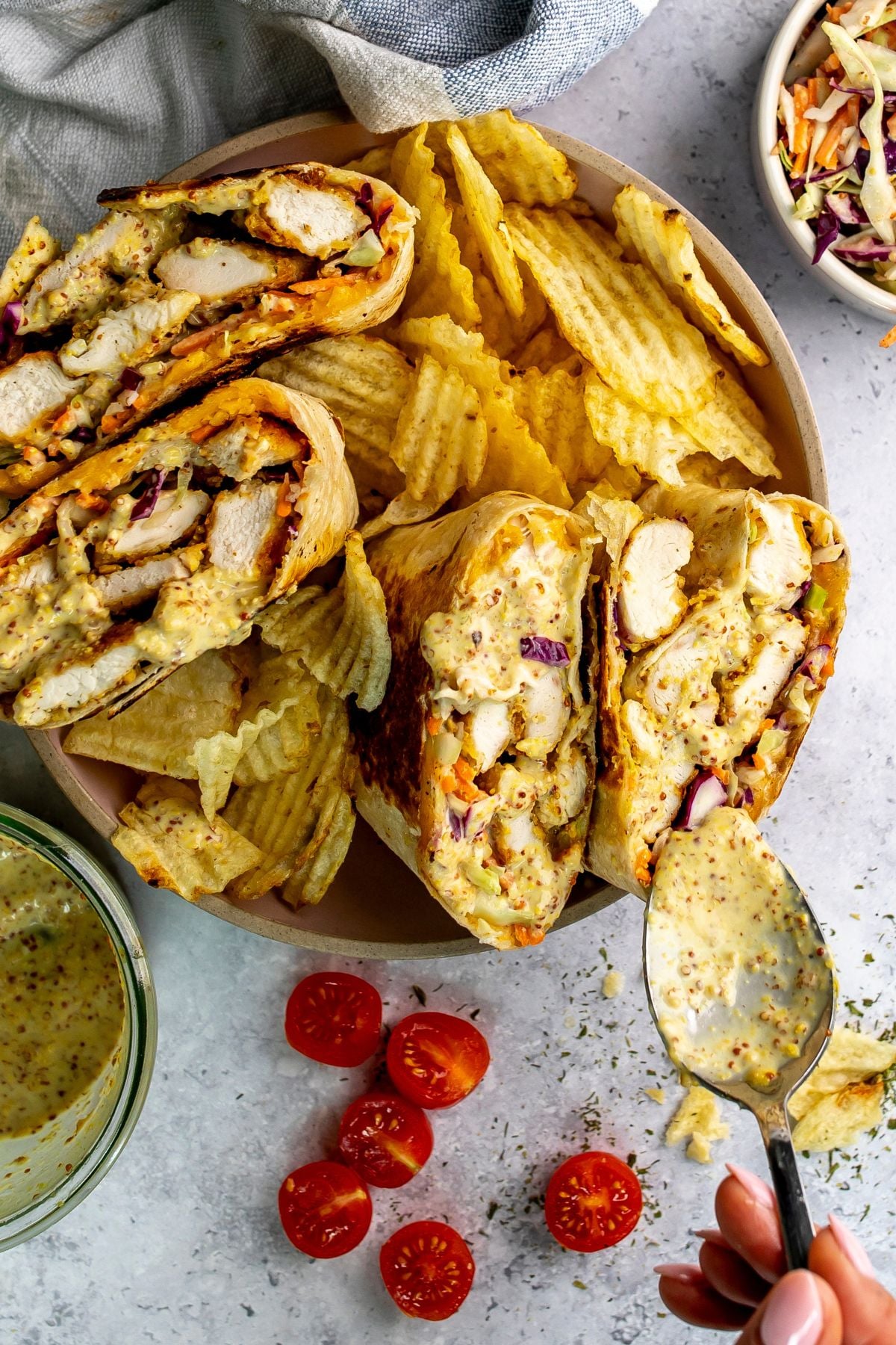 Chicken wraps with honey mustard in bowl with chips.
