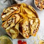 Honey Mustard Chicken wraps in a ceramic bowl with chips on the side.