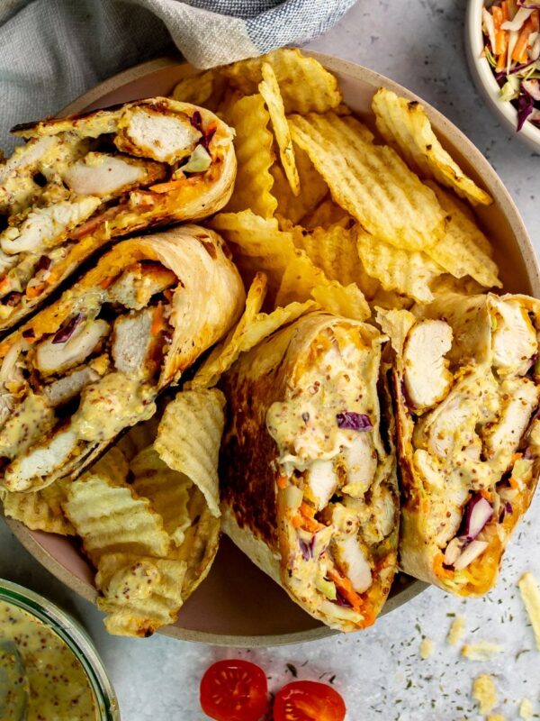 Honey Mustard Chicken wraps in a ceramic bowl with chips on the side.