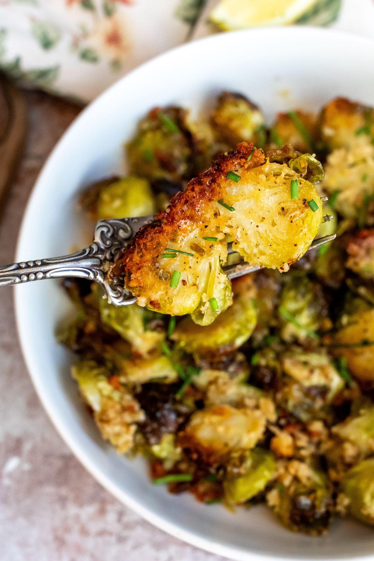 Brussel sprouts crusted in parmesan on a silver fork up close. 