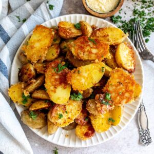 Grey bowl with parmesan potatoes and a silver fork.