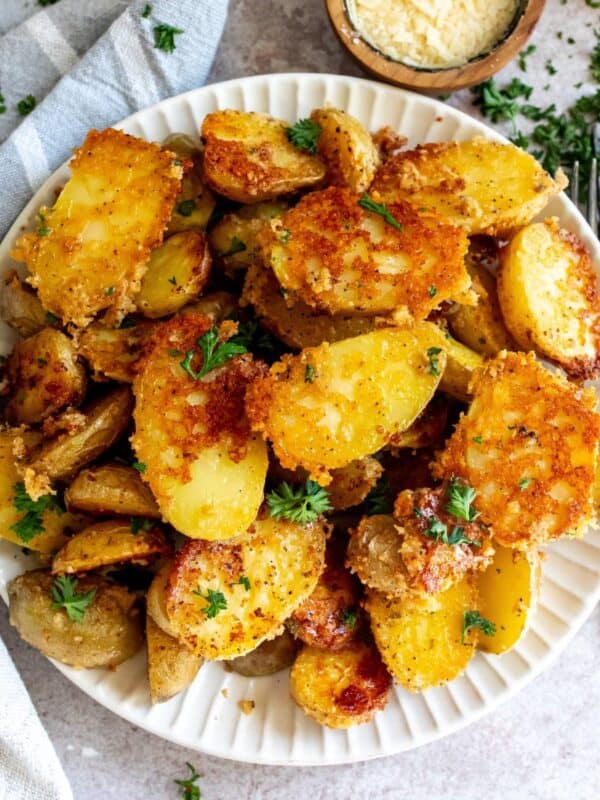 Grey bowl with parmesan potatoes and a silver fork.