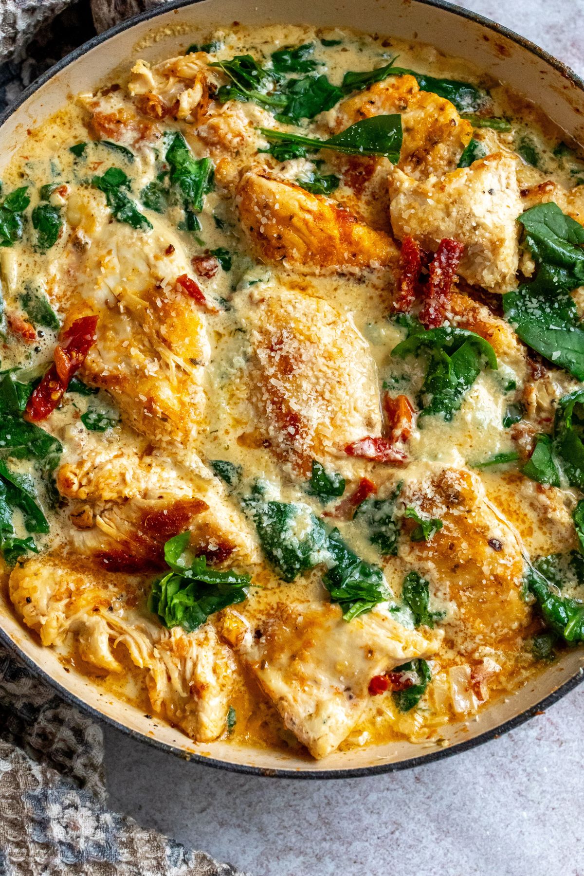 Skillet with chicken and cream sauce and spinach. 