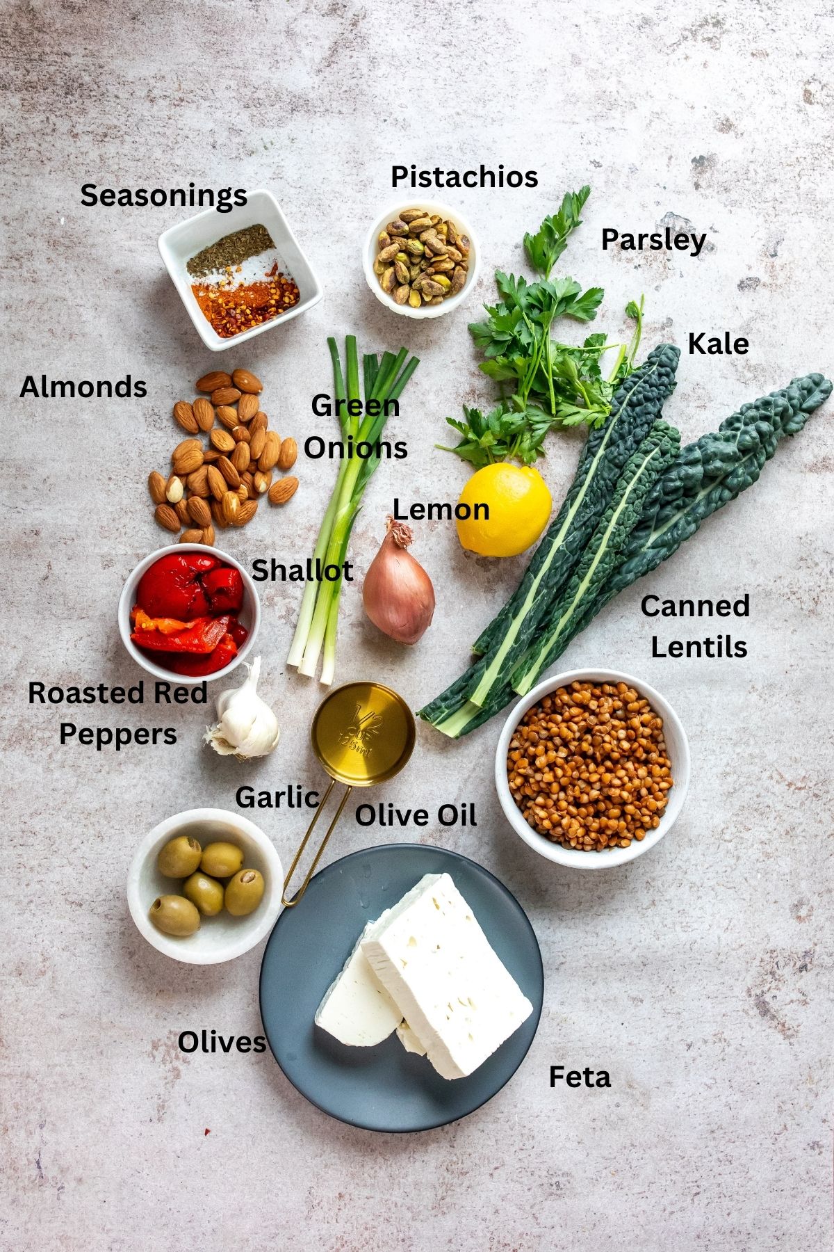 Ingredients needed to make this kale and lentil salad on a counter with small bowls and measuring cups. 