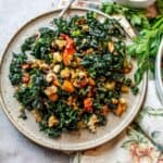 Chopped kale on a speckled plate with a silver spoon on the side.