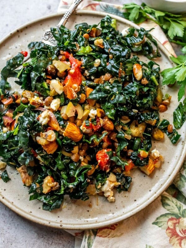 Chopped kale on a speckled plate with a silver spoon on the side.