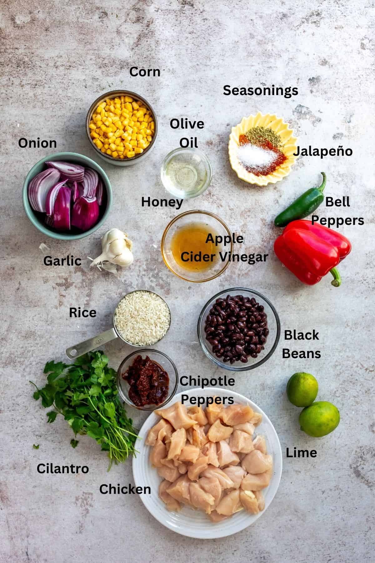 Ingredients to make Southwest Chicken bowls on a counter in small bowls and measuring cups. 