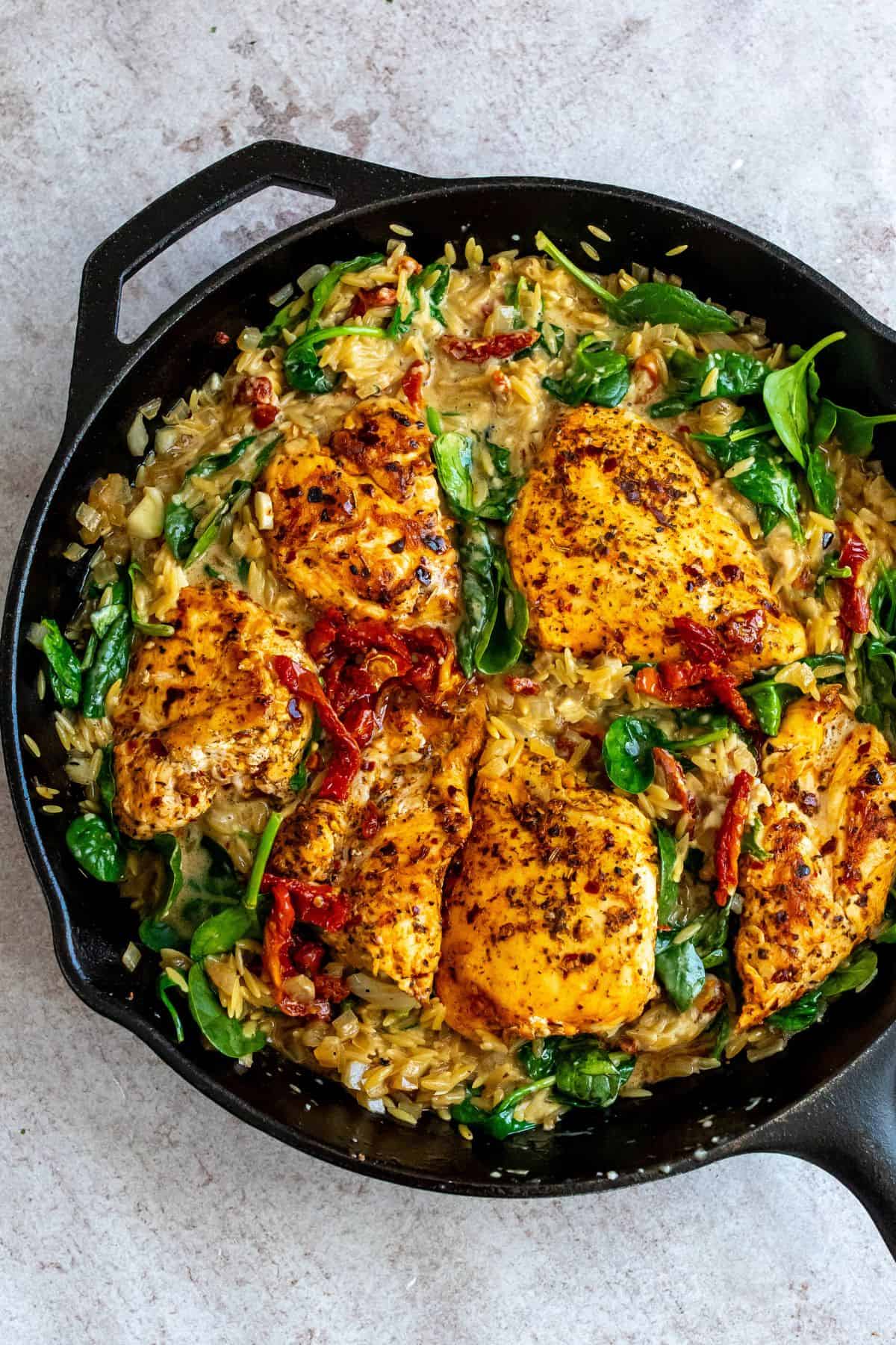 Chicken and orzo skillet with sun dried tomatoes and spinach. 