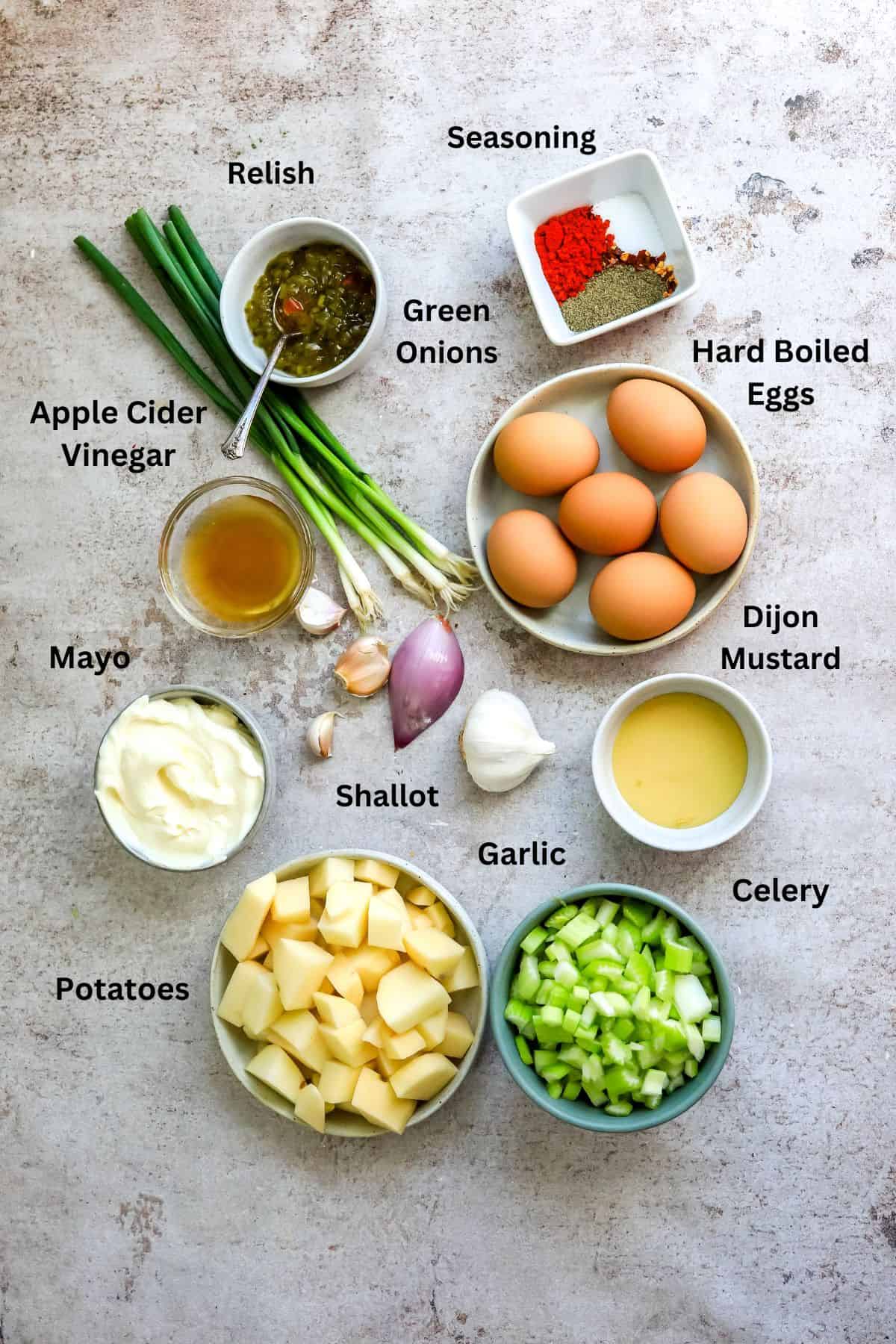 Ingredients needed to make this potato salad in small bowls and measuring cups. 