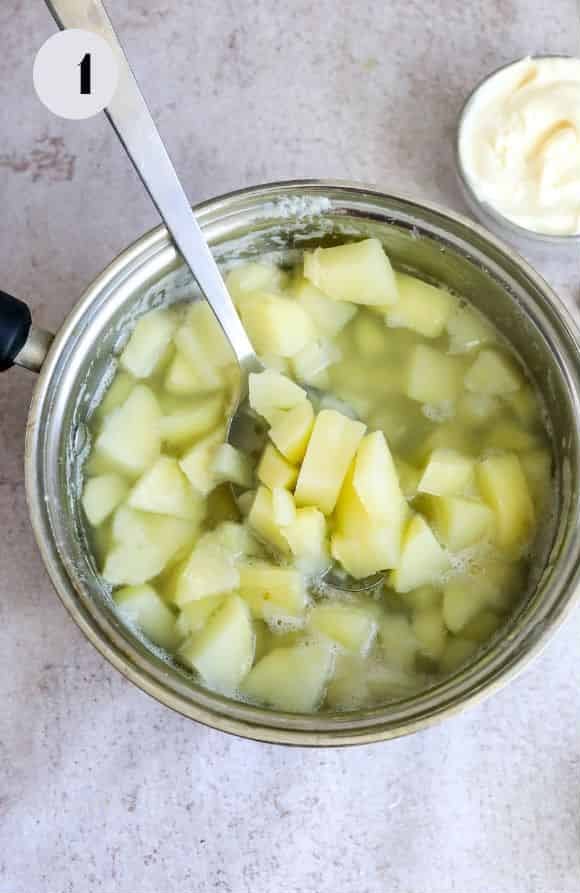 The chopped potatoes in a large pot of boiling water after cooking until tender.