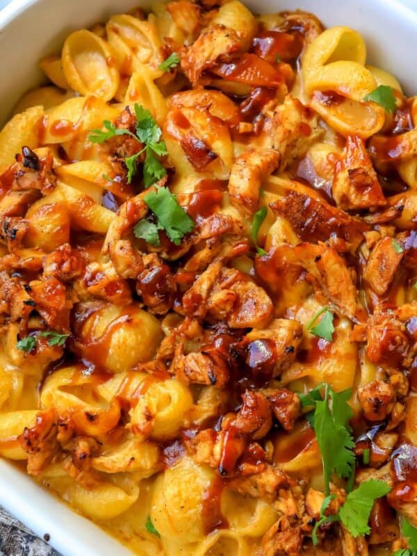 Close up of mac and cheese with bbq chicken mixed in in a white baking dish.