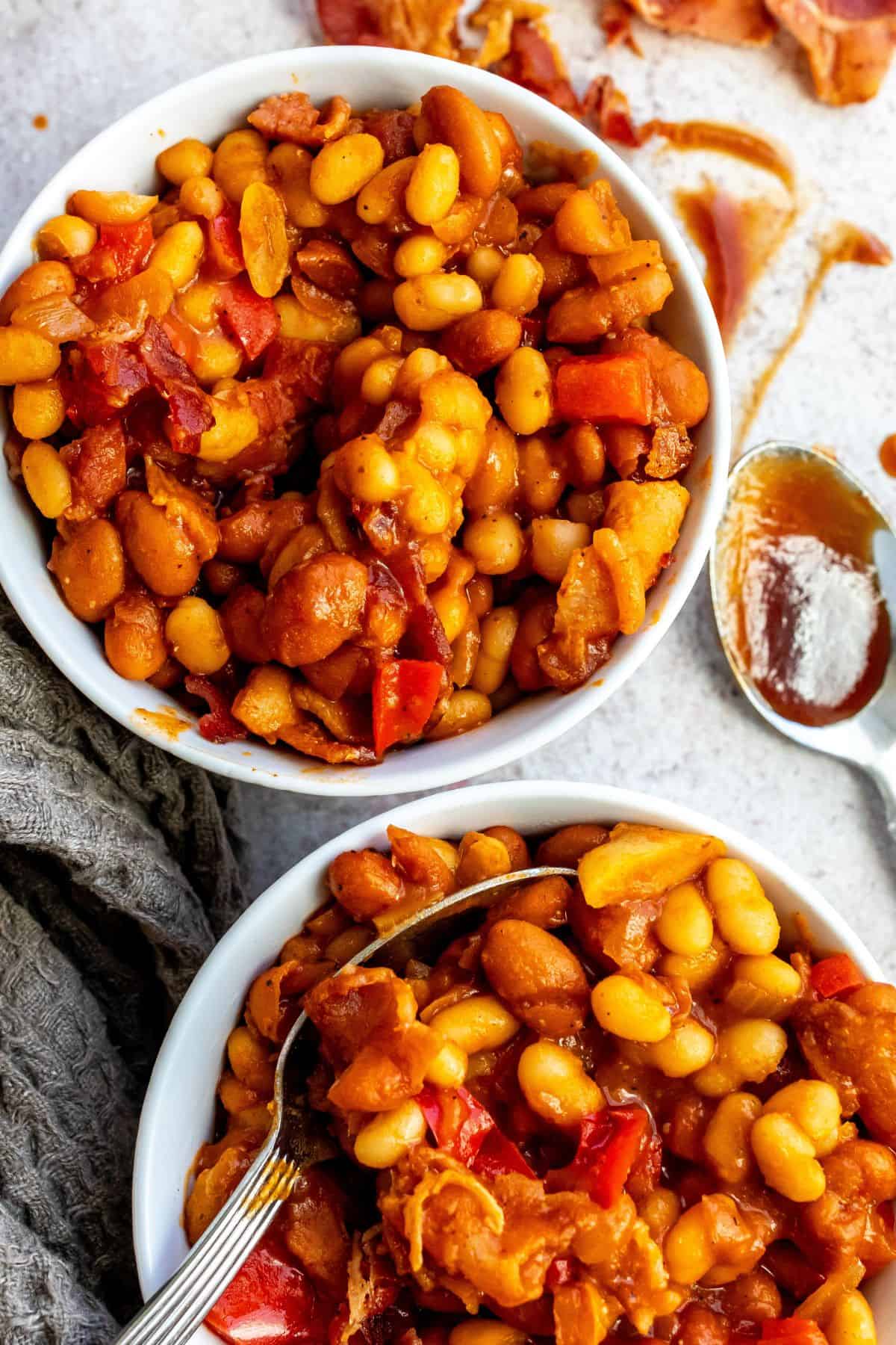 An overhead image of two bowls filled with baked beans.