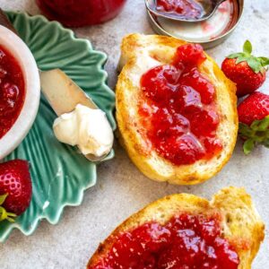 An overhead image of strawberry jam spread on two pieces of toast.