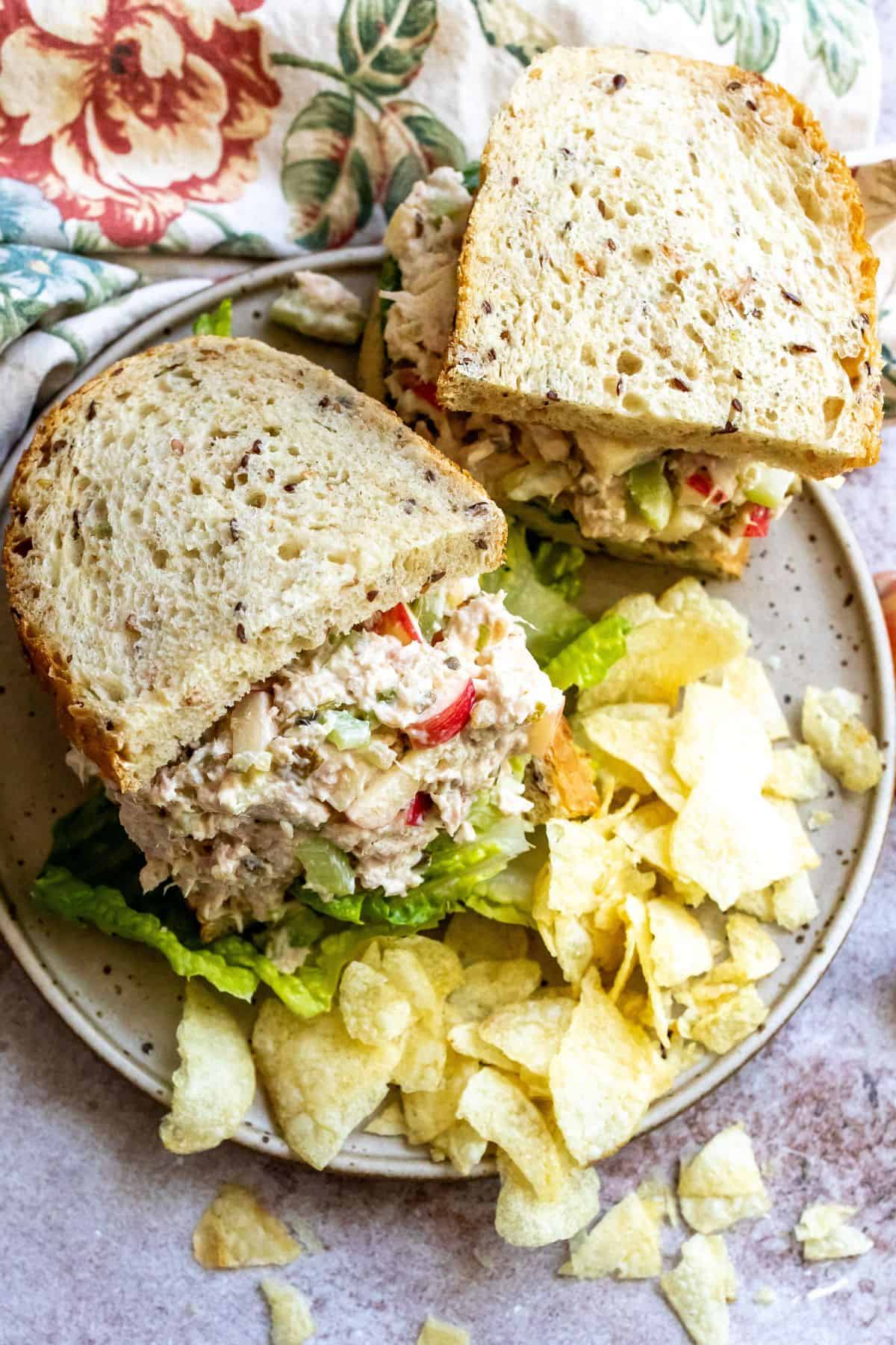 Plate with bread and apples on it. Tuna salad in the bread. 