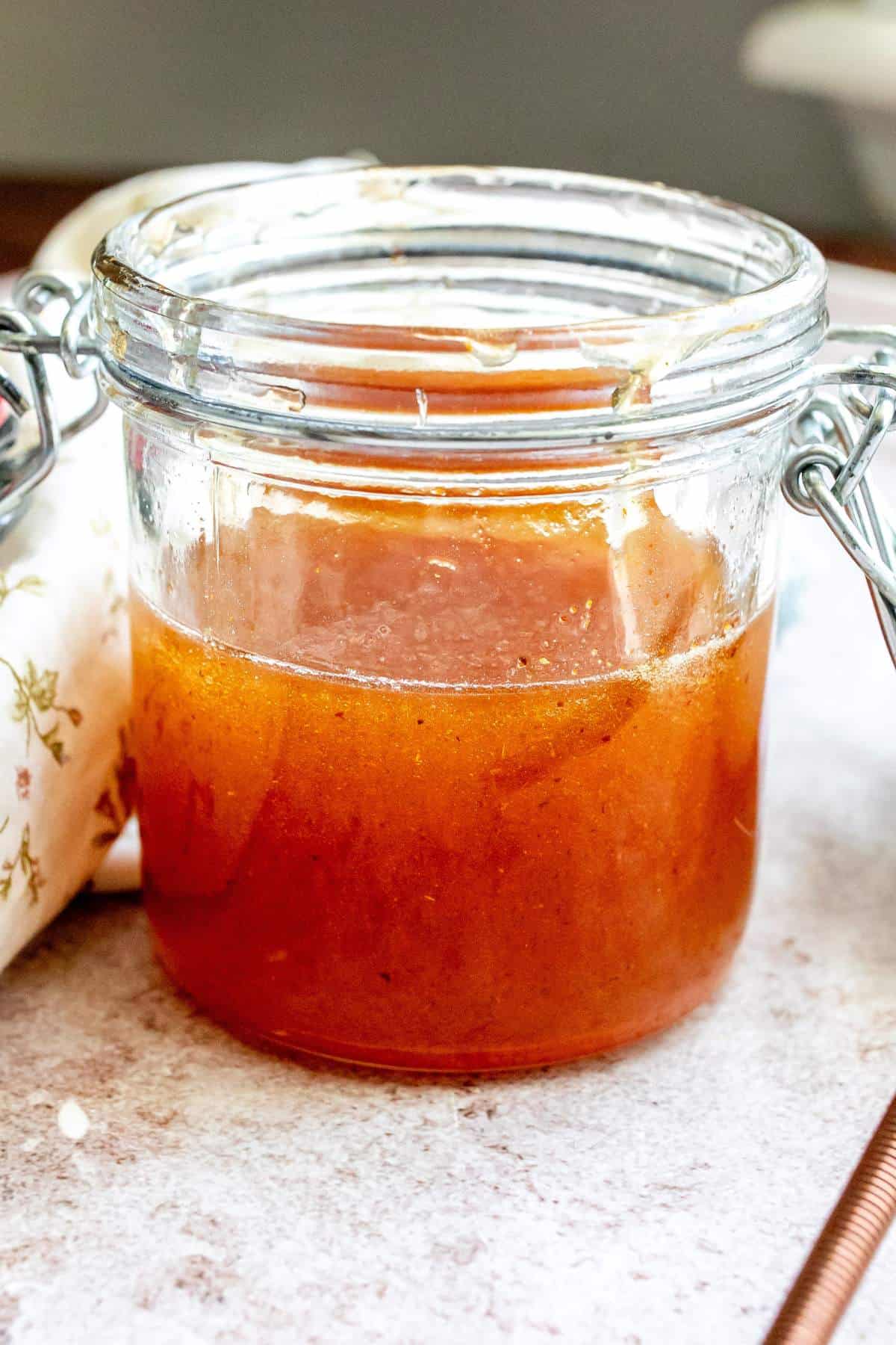 Up close photo of a jar with hot honey in it. 