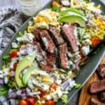 Large serving platter with chopped salad and grilled steak.