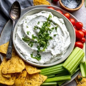 An overhead image of cottage cheese dip, with chips and veggies on the side for dipping.