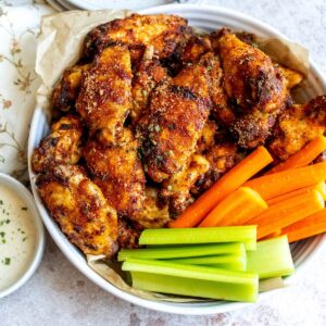 An overhead image of dry rub wings with carrot sticks and celery on the side.