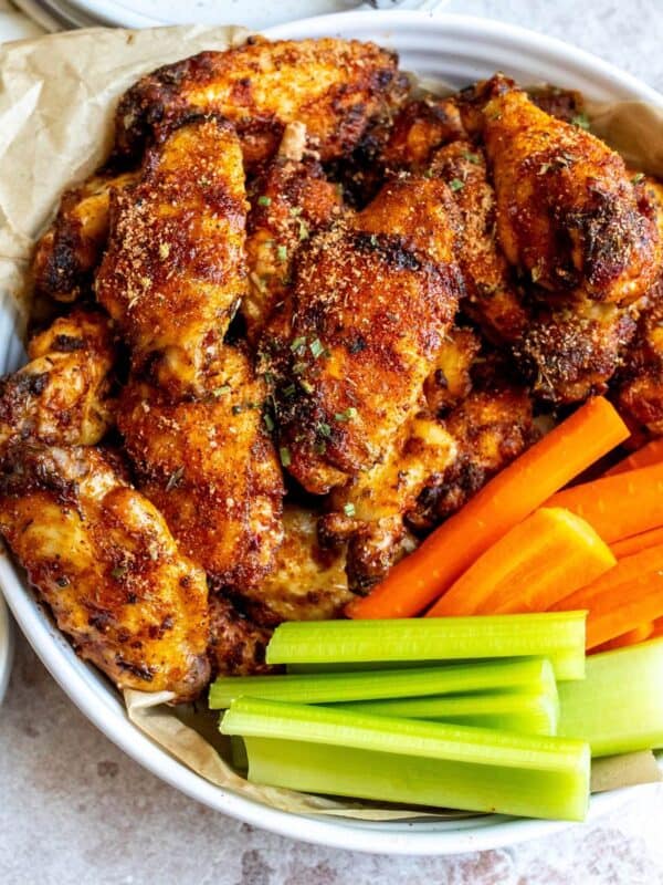 An overhead image of dry rub wings with carrot sticks and celery on the side.