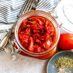 Fire Roasted Tomatoes in a big glass jar with a fork on the side.