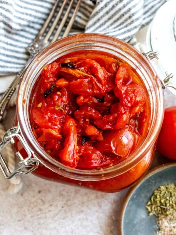 Fire Roasted Tomatoes in a big glass jar with a fork on the side.