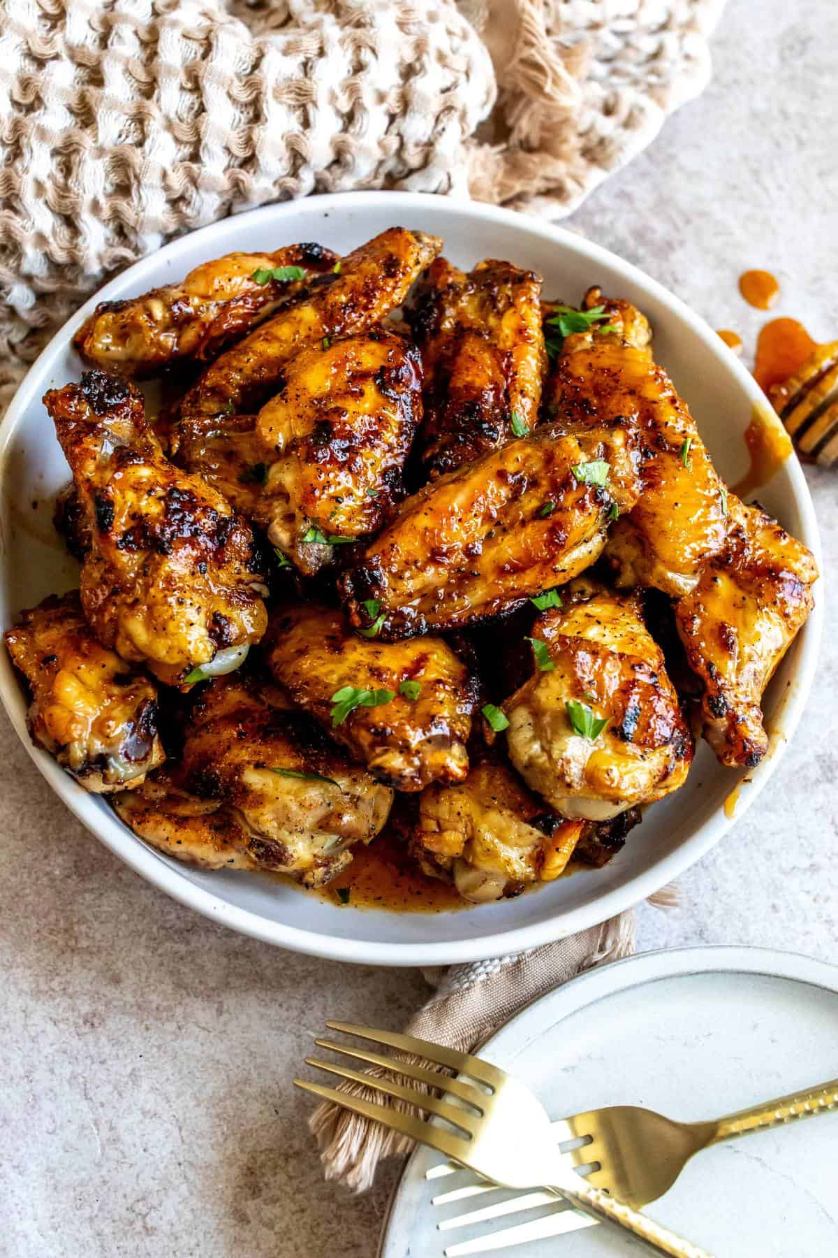 White ceramic bowl with sauce hot honey wings in it. 