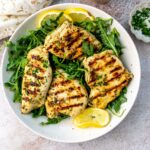 Herb Lemon Chicken on a plate with lemons.