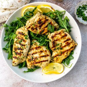 Herb Lemon Chicken on a plate with lemons.