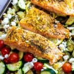 An image of lemon pepper salmon served over baked veggies.