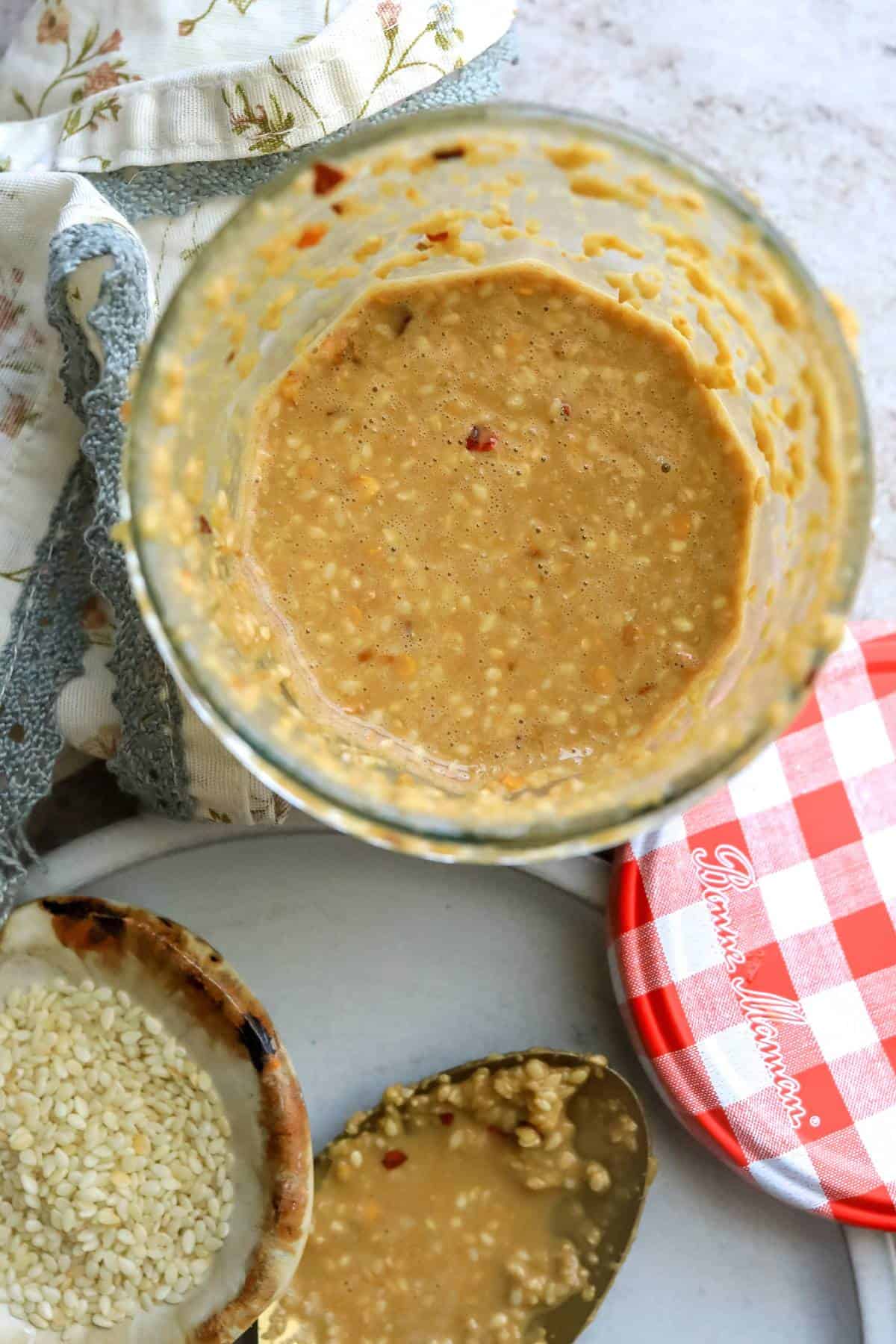 Jar with roasted sesame seed dressing in it. 