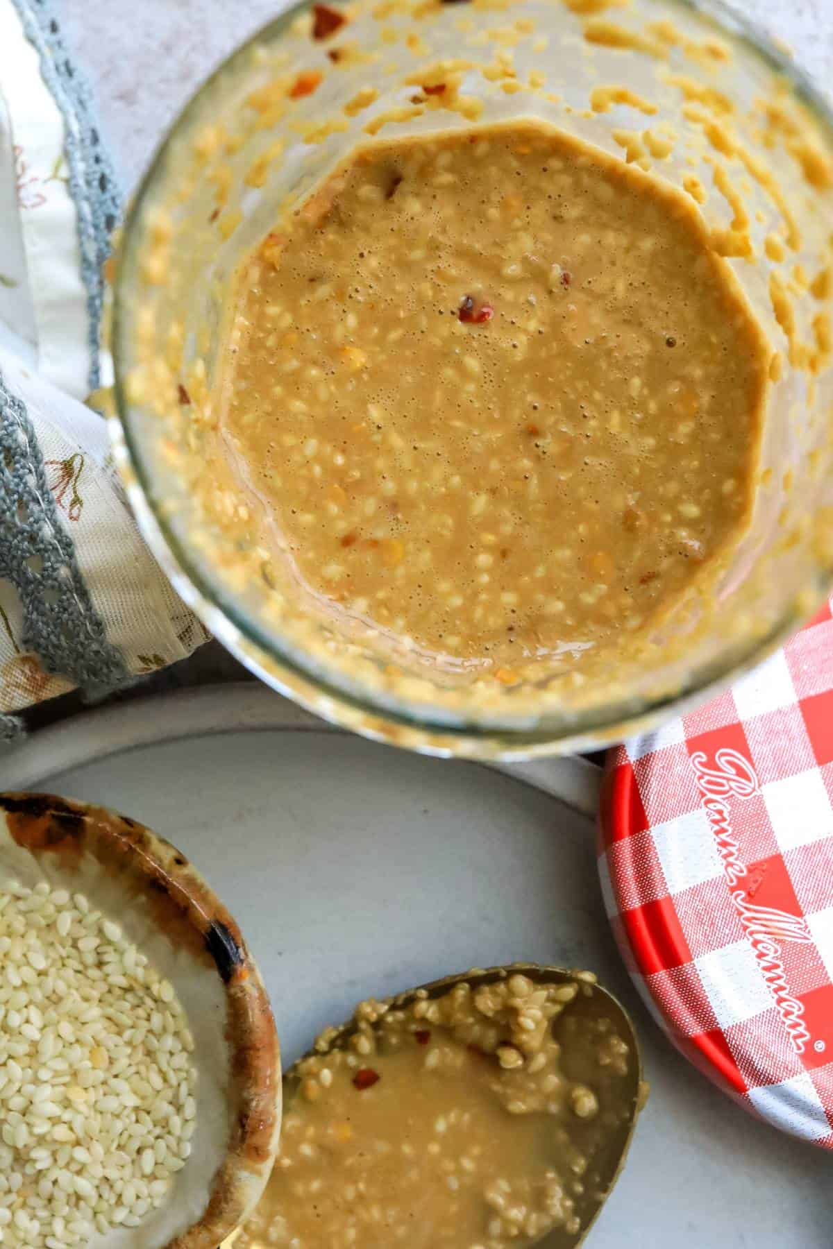 Jar with roasted sesame seed dressing in it. 