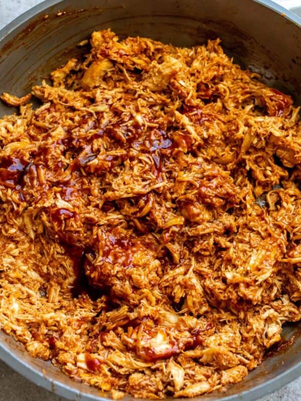 A close up image of shredded BBQ chicken in a skillet.
