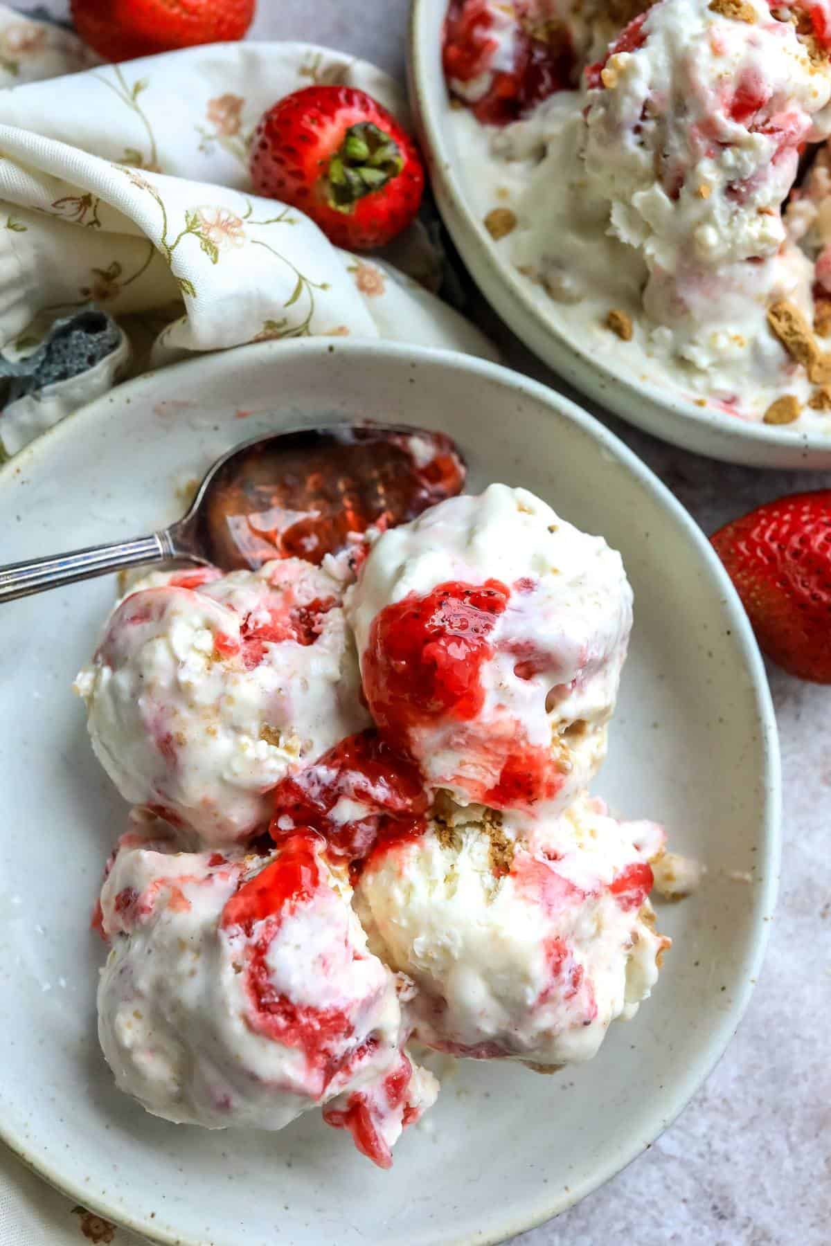 An overhead image of four scoops of strawberry cheesecake ice cream in a bowl.