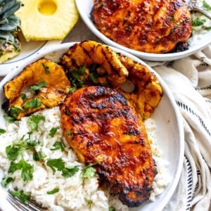 White pottery bowl with glazed Chicken Pineapple Adobo served over rice. Overhead shot.