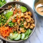 Grey bowls with Shrimp Poke Bowl ingredients. Chopsticks on the side.