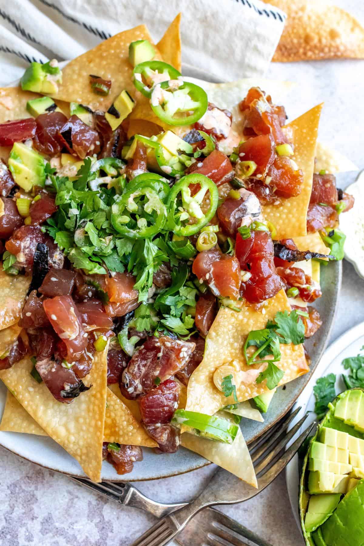 Poke Chip nachos on a plate with toppings. 