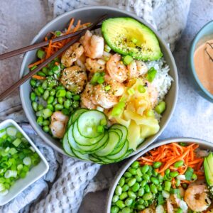 Grey bowls with Shrimp Poke Bowl ingredients. Chopsticks on the side.