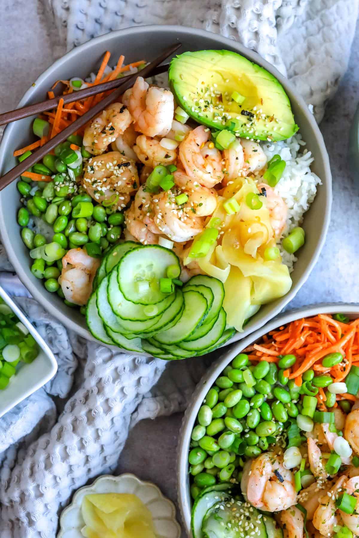 Grey bowls with Shrimp Poke Bowl ingredients. Chopsticks on the side. 