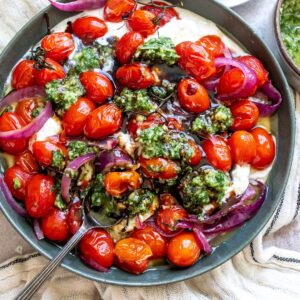 Pesto Burrata in a green bowl with bread to the side.