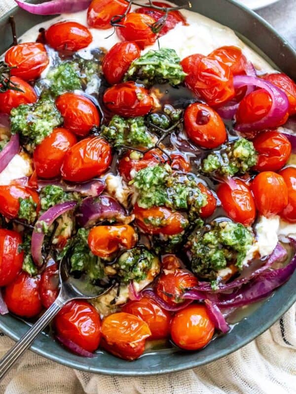 Pesto Burrata in a green bowl with bread to the side.