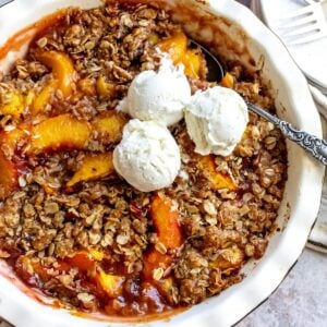 White baking dish with peach oatmeal crumble in it.