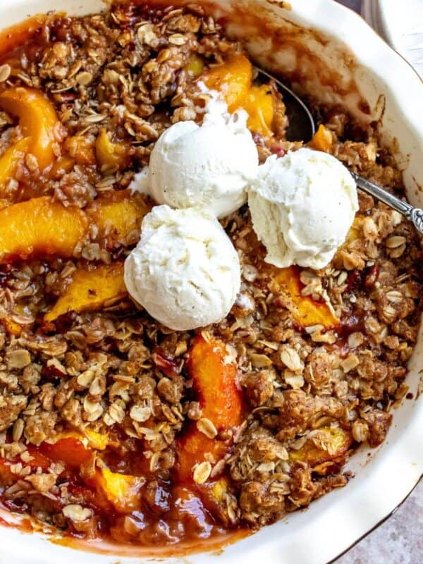 White baking dish with peach oatmeal crumble in it.