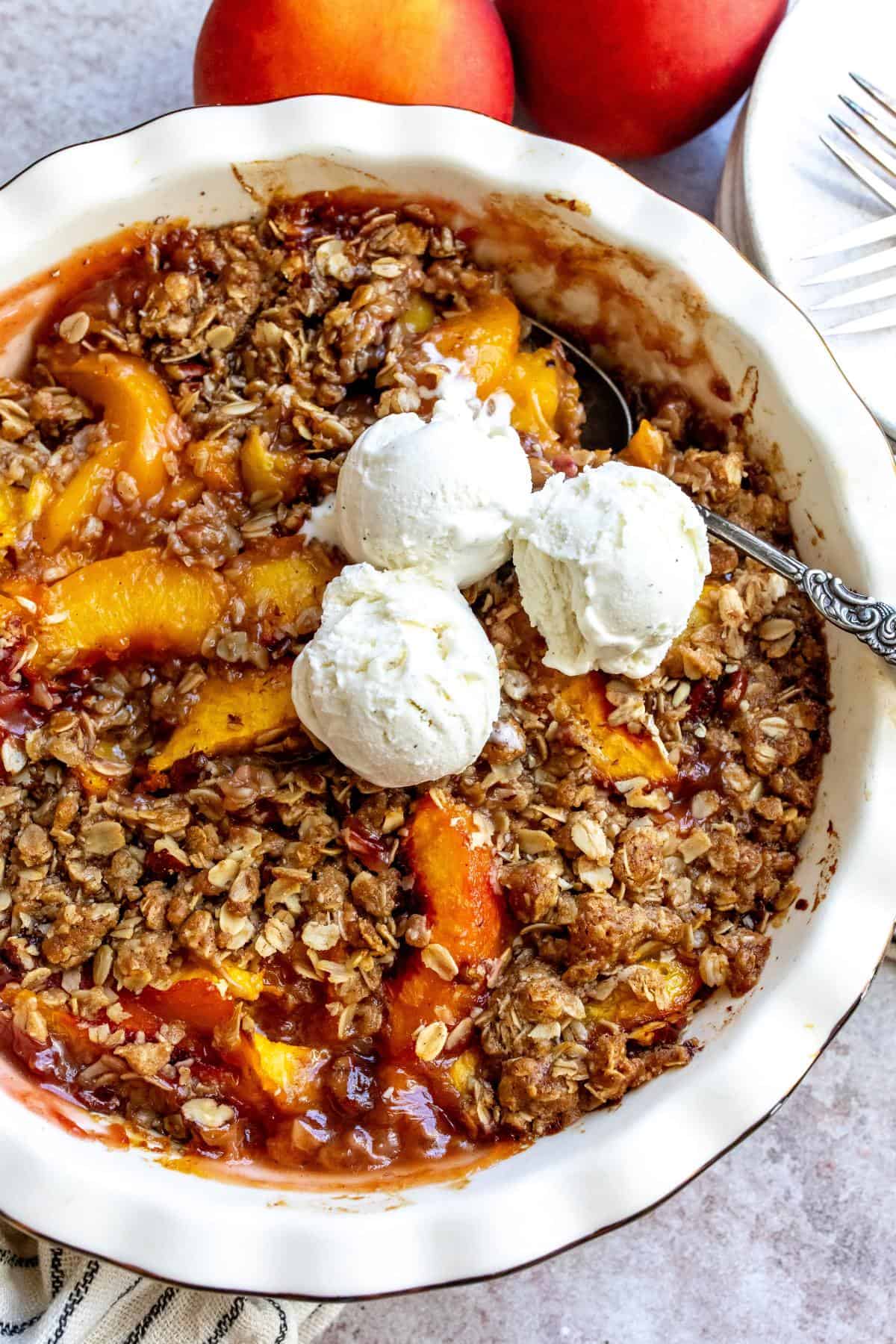 White baking dish with peach oatmeal crumble in it. 