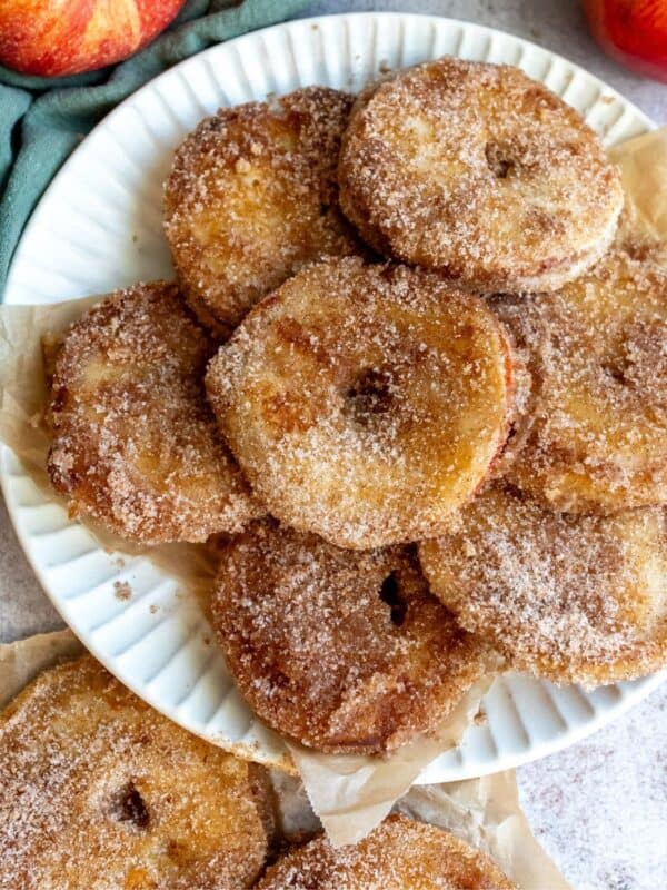 An overhead image of a stack of apple donuts on a plate.