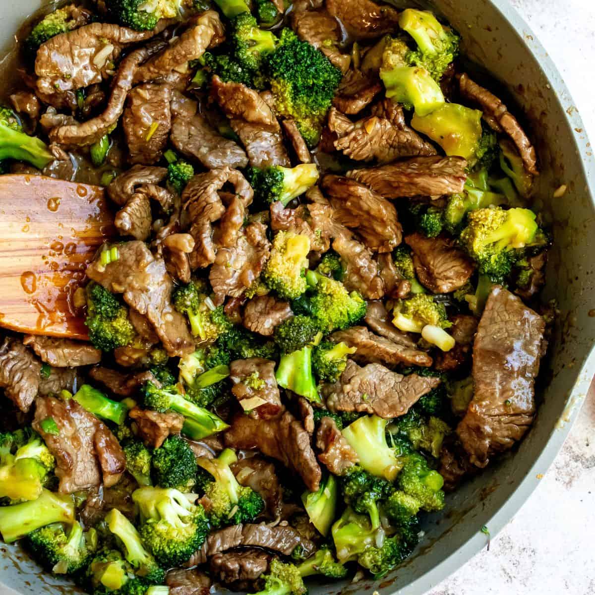 Over head photo of Beef and broccoli recipe in a pink skillet.